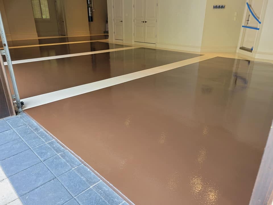 Glossy brown solid-color epoxy garage floor with a white border stripe